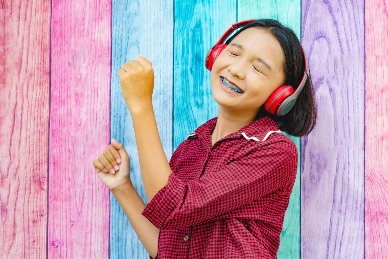 Girl with braces smiling while using a tablet
